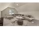 Spacious bonus room with large sectional sofa and window showcasing neighborhood views at 65 Stream View Way, Spring Hope, NC 27882