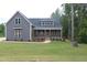Charming home featuring gray siding, a welcoming front porch, and a lush green lawn at 65 Stream View Way, Spring Hope, NC 27882