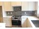 Modern kitchen with stainless steel appliances, stylish backsplash, and white cabinetry at 65 Stream View Way, Spring Hope, NC 27882