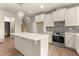 Well-lit kitchen featuring white cabinets, an island, stainless steel appliances, and grey backsplash tiles at 65 Stream View Way, Spring Hope, NC 27882