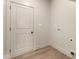 Utility room with wood flooring, electrical outlets, and a door leading to another area at 65 Stream View Way, Spring Hope, NC 27882