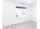 Bright bedroom featuring a window with blinds and neutral carpet at 6808 Lakinsville Ln, Raleigh, NC 27610