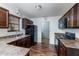 Well-lit kitchen featuring dark wood cabinets, granite countertops, and modern black appliances at 6808 Lakinsville Ln, Raleigh, NC 27610