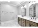 Modern bathroom featuring a double vanity, beautiful mirrors, and stylish marble flooring at 692 Port Dr, Henderson, NC 27537