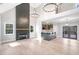 Open-concept living space with a floor-to-ceiling fireplace and light hardwood floors at 692 Port Dr, Henderson, NC 27537