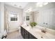 A well-lit bathroom features double sinks, dark wood cabinets, and a large mirror reflecting the natural light at 706 Oldwyck Dr, Fuquay Varina, NC 27526