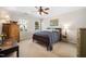 Cozy bedroom with a wooden bed frame, ceiling fan, and natural light streaming through the two windows at 706 Oldwyck Dr, Fuquay Varina, NC 27526