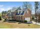 Side view of a brick home with an attached garage, well-maintained lawn, and mature trees at 706 Oldwyck Dr, Fuquay Varina, NC 27526