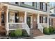 Inviting front porch with brick accents, white railings, and decorative hanging plants at 706 Oldwyck Dr, Fuquay Varina, NC 27526