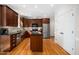 A modern kitchen features stainless steel appliances, dark wood cabinets, and an island with a black countertop at 706 Oldwyck Dr, Fuquay Varina, NC 27526