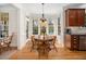 Bright eat-in kitchen with hardwood floors, large windows overlooking the pool and garden, and a pendant light fixture at 706 Oldwyck Dr, Fuquay Varina, NC 27526