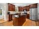 Modern kitchen featuring dark wood cabinets, granite countertops, stainless steel appliances, and an island at 706 Oldwyck Dr, Fuquay Varina, NC 27526