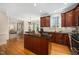 Open kitchen layout flows to eating area and other rooms and features hardwood floors and a center island at 706 Oldwyck Dr, Fuquay Varina, NC 27526