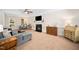 Spacious living room with a cozy fireplace, soft carpet, and ceiling fan provides a comfortable atmosphere at 706 Oldwyck Dr, Fuquay Varina, NC 27526
