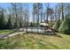A fenced swimming pool with an umbrella, mature trees, and grassy backyard at 706 Oldwyck Dr, Fuquay Varina, NC 27526