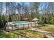 Aerial view of a private backyard pool surrounded by lush trees and a fenced-in area at 706 Oldwyck Dr, Fuquay Varina, NC 27526