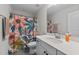Bright bathroom with a white vanity, quartz countertop, modern fixtures, and a floral shower curtain at 75 Red Crabapple Ct, Clayton, NC 27520