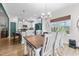 Comfortable dining area with a rustic table and chairs, lots of light, flows into modern kitchen at 75 Red Crabapple Ct, Clayton, NC 27520