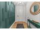 Stylish entryway featuring a decorative green wall, a modern light fixture, and a round mirror at 75 Red Crabapple Ct, Clayton, NC 27520
