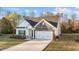 Inviting single-Gathering home with stone and vinyl siding, a two-car garage, and a well-manicured front lawn at 75 Red Crabapple Ct, Clayton, NC 27520