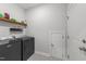Functional laundry room features modern appliances, patterned tile floor, and convenient shelving at 75 Red Crabapple Ct, Clayton, NC 27520