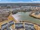 Panoramic aerial view showcasing townhomes with a shimmering lake, walking path, and picturesque neighborhood surroundings at 818 Lilyquist Way, Wake Forest, NC 27587