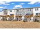 Backyard with new townhomes featuring private wooden decks and well-maintained lawn at 818 Lilyquist Way, Wake Forest, NC 27587