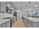 Modern kitchen featuring a marble island, stainless appliances, and gray cabinets with ample counter space at 818 Lilyquist Way, Wake Forest, NC 27587