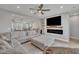 Open-concept living room features modern fireplace, large TV, and connects seamlessly with kitchen and dining area at 818 Lilyquist Way, Wake Forest, NC 27587