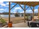 Covered patio with views of a lake, cozy seating, and a well-maintained lawn at 818 Lilyquist Way, Wake Forest, NC 27587