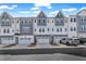 Charming townhomes with white siding, gray accents, garages, and well-maintained landscaping on a sunny day at 818 Lilyquist Way, Wake Forest, NC 27587