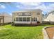 Expansive back exterior featuring a screened porch, large windows, and a well-maintained lawn at 8215 Cushing St, Raleigh, NC 27613