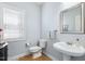 Cozy half bath featuring a pedestal sink, gray walls, and a window with blinds at 8215 Cushing St, Raleigh, NC 27613