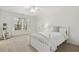 Bright bedroom featuring a ceiling fan, large window, and carpeted floors at 8215 Cushing St, Raleigh, NC 27613