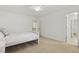 Bright bedroom featuring a ceiling fan, large window, and carpeted floors at 8215 Cushing St, Raleigh, NC 27613