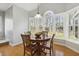Bright breakfast nook features hardwood floor, wooden table and chairs, and large windows offering backyard views at 8215 Cushing St, Raleigh, NC 27613