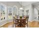 Breakfast nook with hardwood floors, wooden table and chairs, multiple windows offering backyard view and natural light at 8215 Cushing St, Raleigh, NC 27613