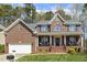 Attractive brick home with a two-car garage, covered front porch, and manicured landscaping at 8215 Cushing St, Raleigh, NC 27613
