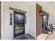Close-up view of the front door and porch with brick detailing and outdoor seating at 8215 Cushing St, Raleigh, NC 27613