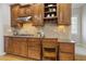 Kitchen with wood cabinets, granite countertops, stainless steel vent hood, gas cooktop and built-in desk space at 8215 Cushing St, Raleigh, NC 27613