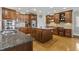 Kitchen with wood cabinets, granite countertops, stainless steel appliances, central island, hardwood floor and recessed lights at 8215 Cushing St, Raleigh, NC 27613