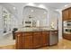 Open concept kitchen with granite countertops, wood cabinets, stainless steel appliances and connection to living room through archways at 8215 Cushing St, Raleigh, NC 27613