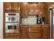 Kitchen with stainless steel microwave and oven, wood cabinets, granite countertops, tile backsplash and coffee maker at 8215 Cushing St, Raleigh, NC 27613