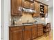 Kitchen with wood cabinets, granite countertops, stainless steel vent hood, gas cooktop and built-in desk at 8215 Cushing St, Raleigh, NC 27613
