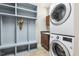 Well-organized laundry room with gray shelving, sink, and stacked washer and dryer at 8215 Cushing St, Raleigh, NC 27613