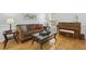 Inviting living room featuring hardwood floors, a cozy couch, and an upright piano at 8215 Cushing St, Raleigh, NC 27613