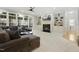 Living area with fireplace, built-in shelving, large windows, and a sectional sofa at 8215 Cushing St, Raleigh, NC 27613
