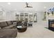 Open living room with large windows, a ceiling fan, and a comfortable sectional couch at 8215 Cushing St, Raleigh, NC 27613