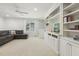 Spacious living room featuring a large bookcase, ceiling fan, and a comfortable gray sectional sofa at 8215 Cushing St, Raleigh, NC 27613