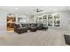 Inviting living room featuring a large sectional sofa, plenty of natural light, and neutral carpet at 8215 Cushing St, Raleigh, NC 27613